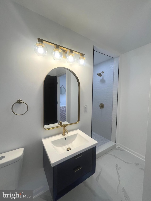 bathroom with vanity, toilet, marble finish floor, and walk in shower