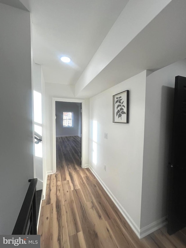 hallway with baseboards and wood finished floors