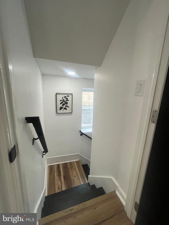 stairway with baseboards and wood finished floors