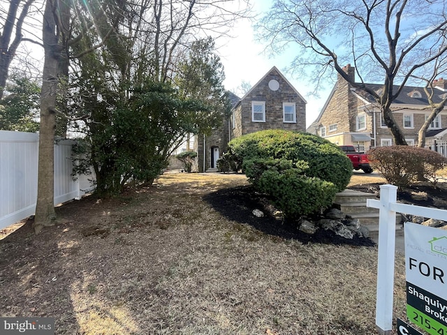 exterior space with stone siding and fence