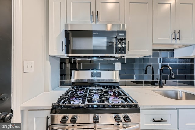 kitchen featuring a sink, tasteful backsplash, appliances with stainless steel finishes, and white cabinets