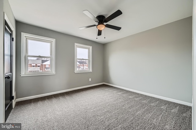 spare room with baseboards, ceiling fan, and carpet flooring