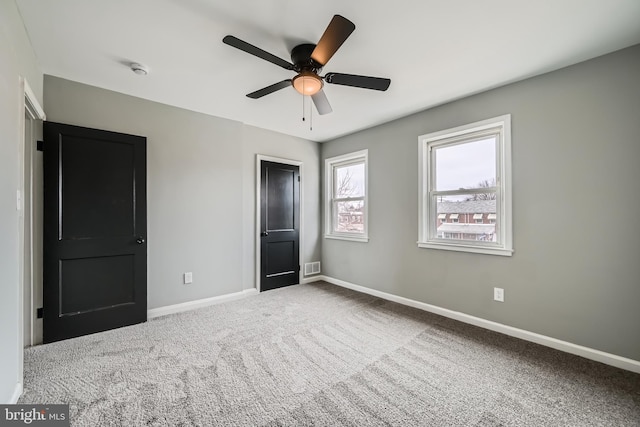 unfurnished bedroom with visible vents, baseboards, ceiling fan, and carpet flooring