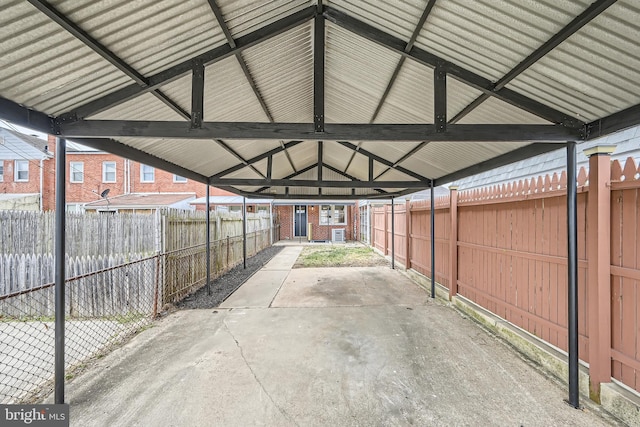 view of parking / parking lot featuring a carport and fence