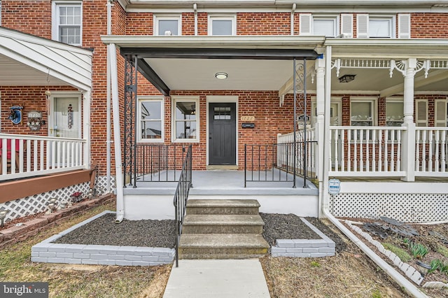 property entrance with brick siding and covered porch