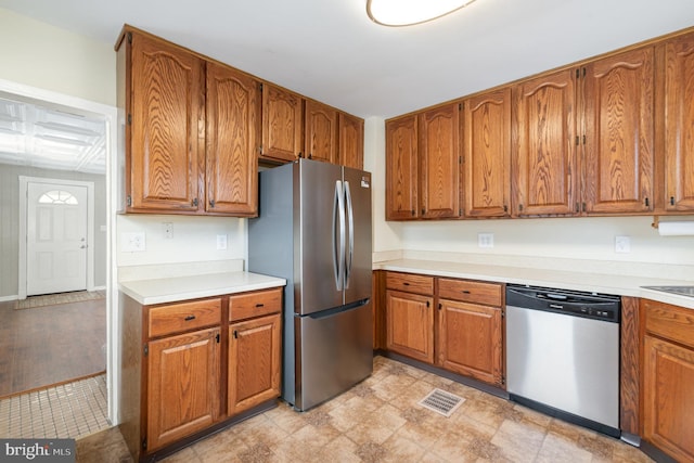 kitchen with brown cabinets, appliances with stainless steel finishes, and light countertops