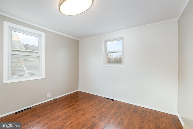 unfurnished room featuring visible vents, baseboards, dark wood-style flooring, and crown molding