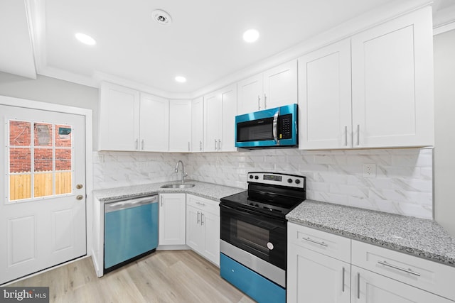 kitchen featuring stainless steel microwave, range with electric stovetop, dishwashing machine, and white cabinets