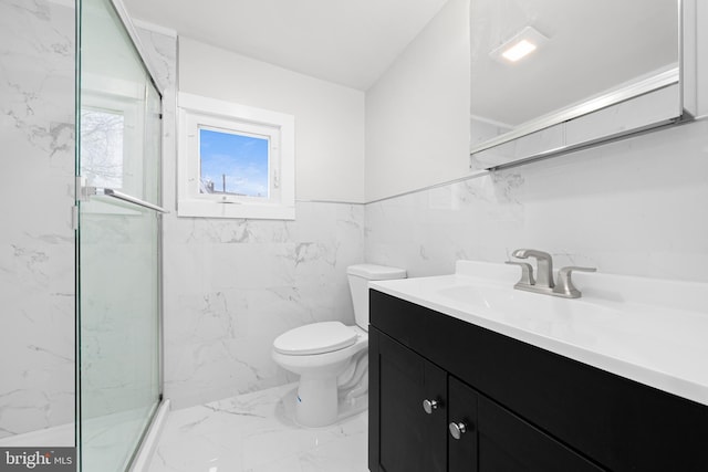 full bath featuring toilet, marble finish floor, a marble finish shower, tile walls, and vanity