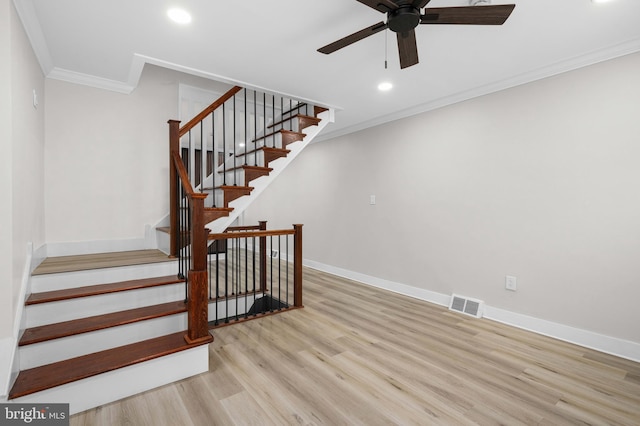 stairs featuring visible vents, a ceiling fan, wood finished floors, crown molding, and baseboards