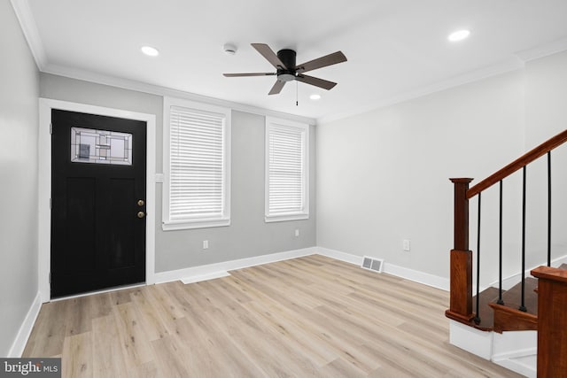 foyer entrance featuring visible vents, crown molding, stairs, and light wood-style floors