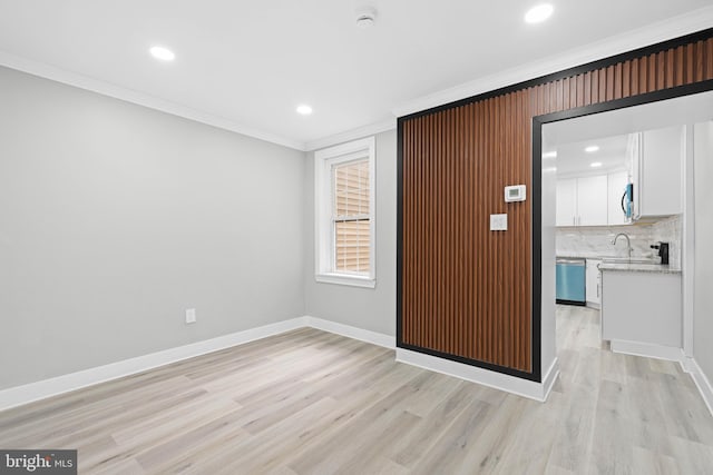 empty room with crown molding, recessed lighting, baseboards, and light wood-type flooring