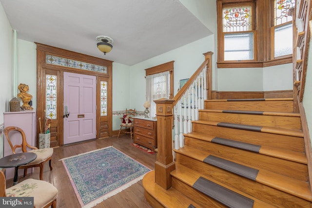 foyer featuring stairs and wood finished floors