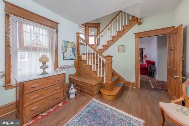 stairway featuring baseboards and wood-type flooring