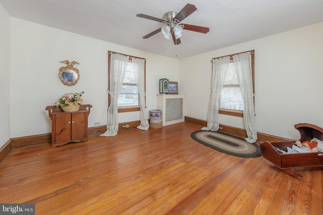 miscellaneous room featuring baseboards, ceiling fan, and hardwood / wood-style floors