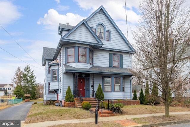 view of front of home featuring cooling unit and roof with shingles