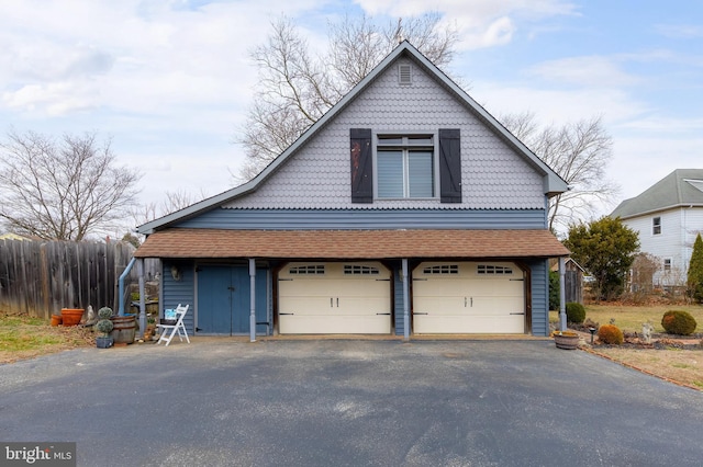 view of front facade with driveway and fence