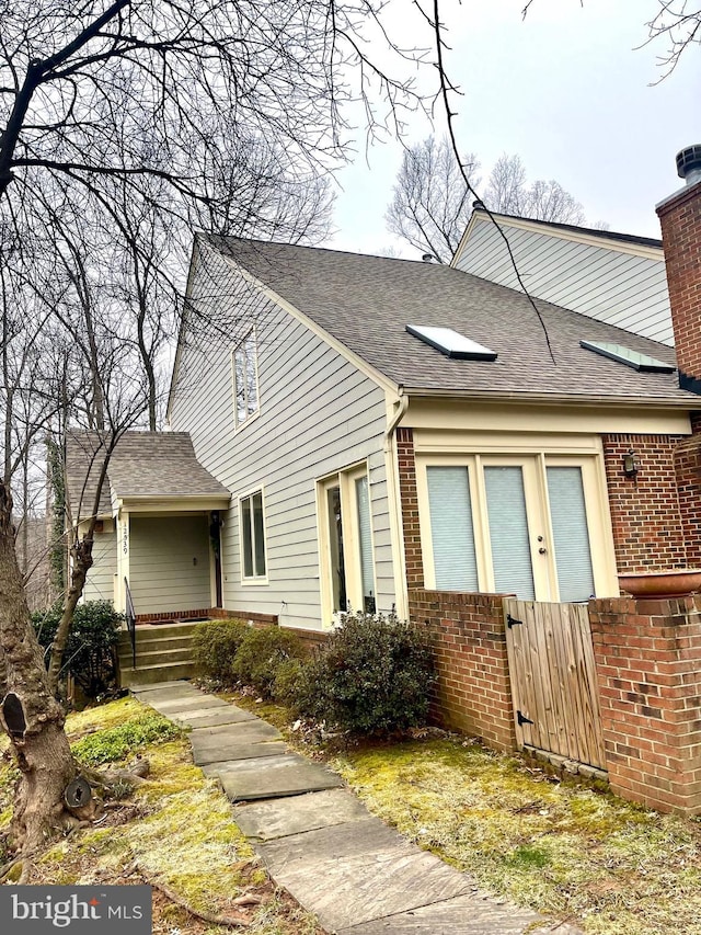 multi unit property with brick siding and roof with shingles