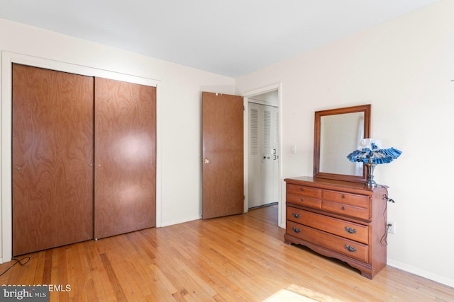 unfurnished bedroom featuring a closet and light wood finished floors