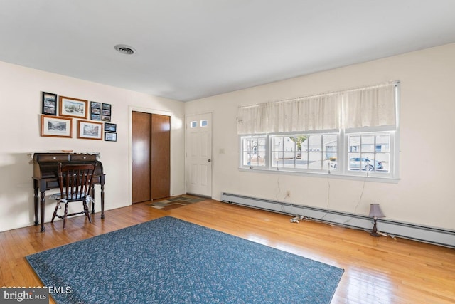 entrance foyer with visible vents, wood-type flooring, and a baseboard radiator