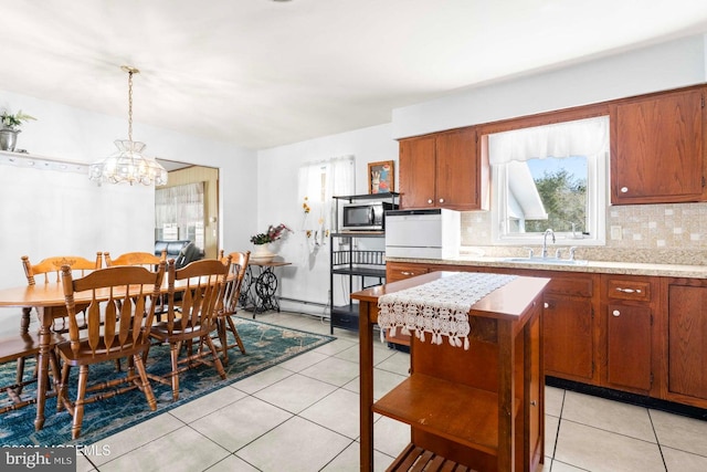 dining room featuring light tile patterned flooring, a chandelier, and a baseboard heating unit