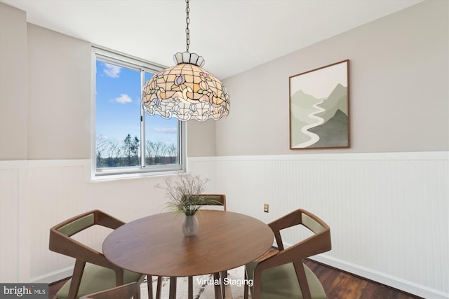 dining room with wood finished floors and wainscoting