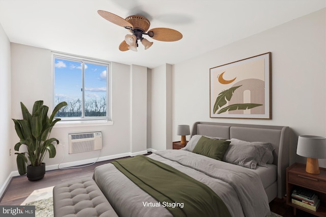 bedroom with ceiling fan, an AC wall unit, baseboards, and wood finished floors