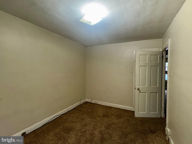 unfurnished room with carpet and baseboards