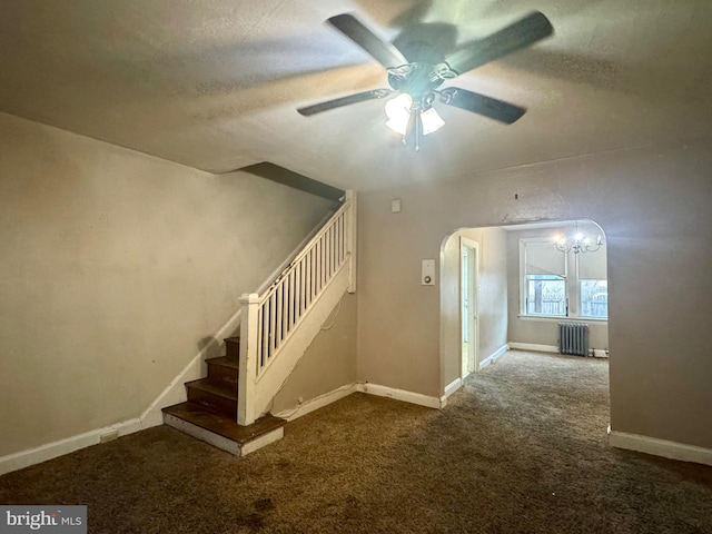 stairs with a textured ceiling, carpet, radiator heating unit, and a ceiling fan