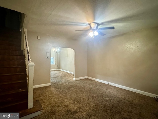 spare room featuring a ceiling fan, baseboards, arched walkways, stairs, and carpet flooring