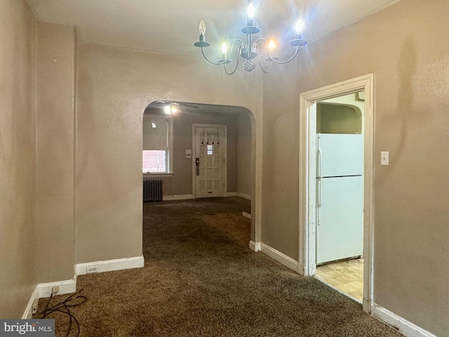 corridor featuring arched walkways, a notable chandelier, radiator heating unit, and carpet