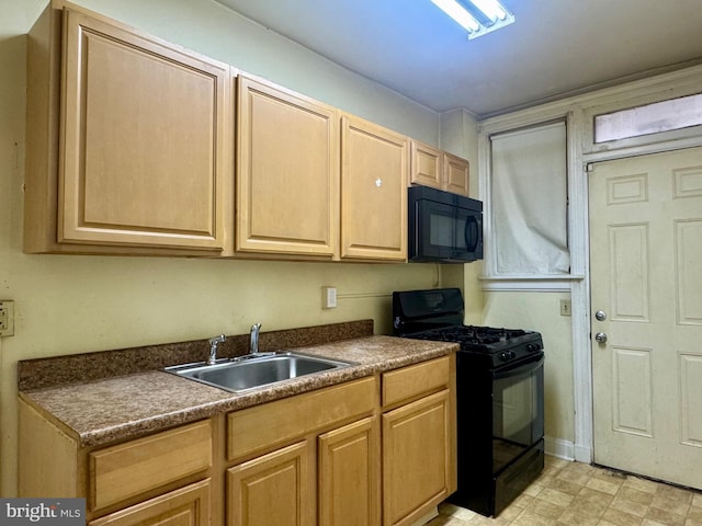 kitchen with a sink, dark countertops, black appliances, and light brown cabinets