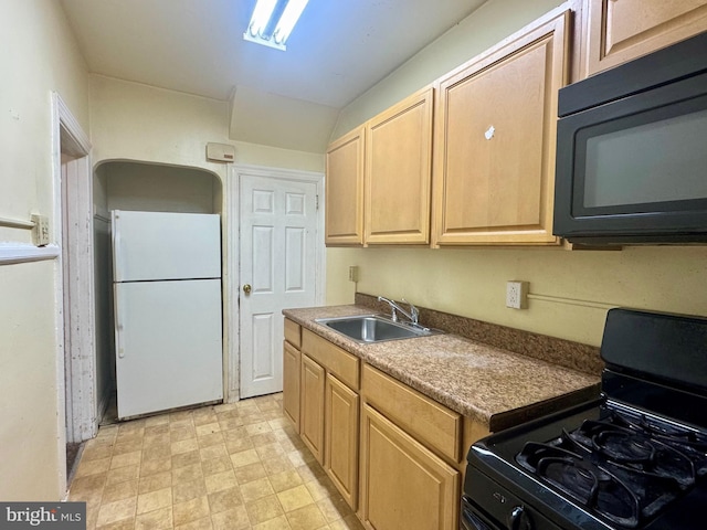 kitchen featuring light floors, light brown cabinets, black appliances, and a sink