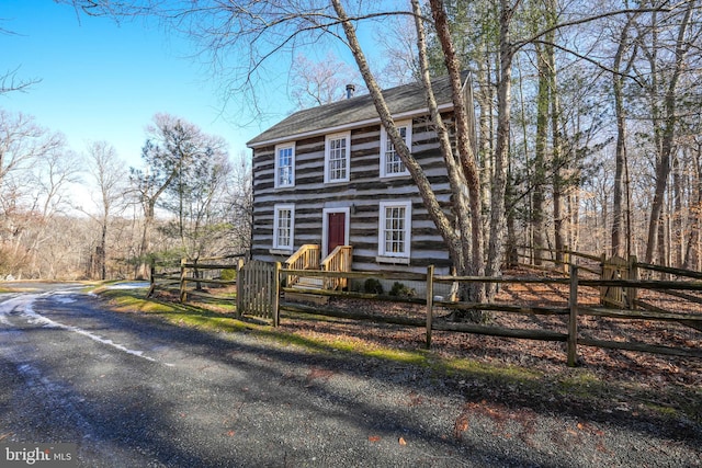 view of front of property with a fenced front yard and a shingled roof