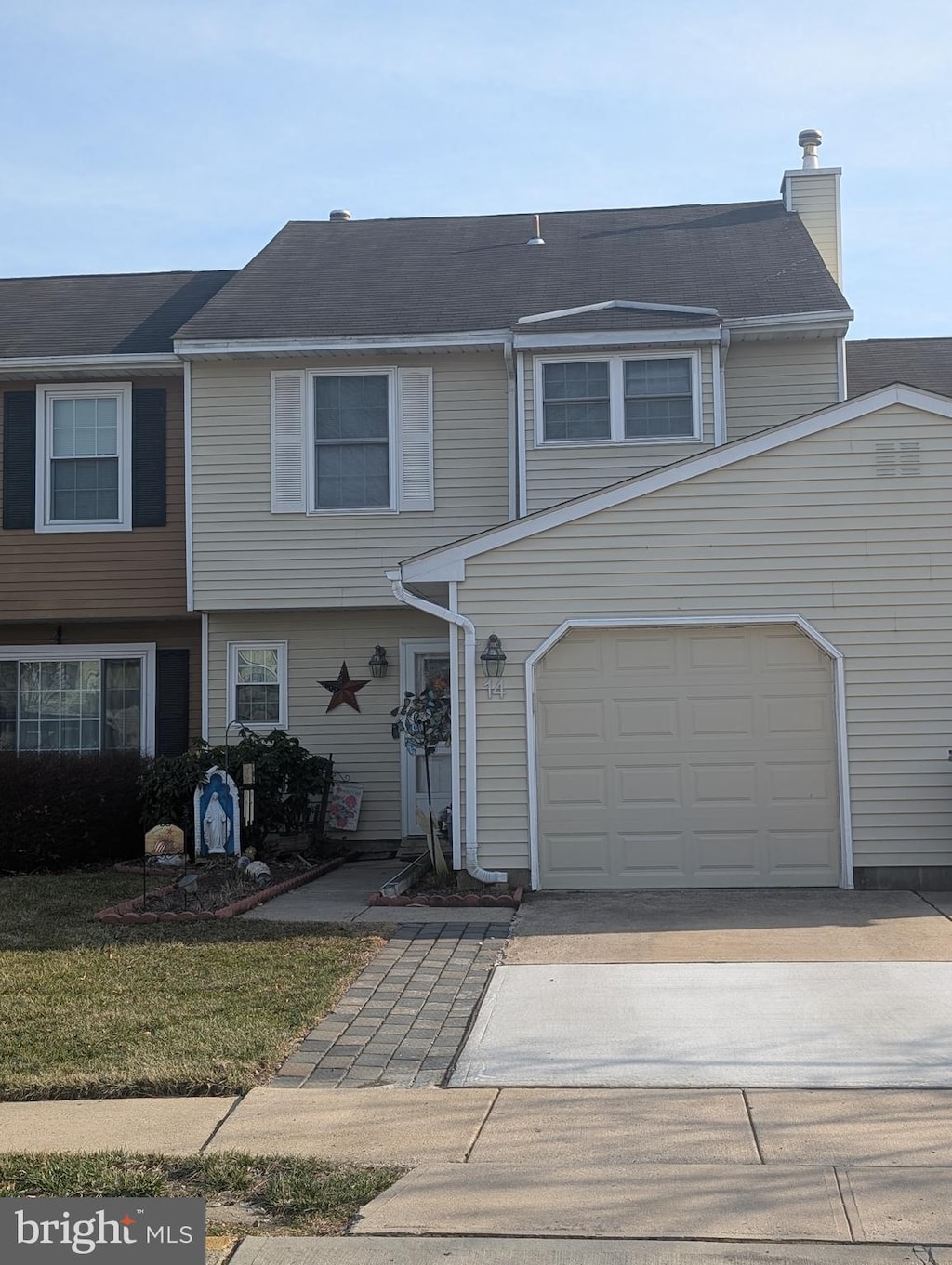 multi unit property featuring driveway, an attached garage, and a chimney