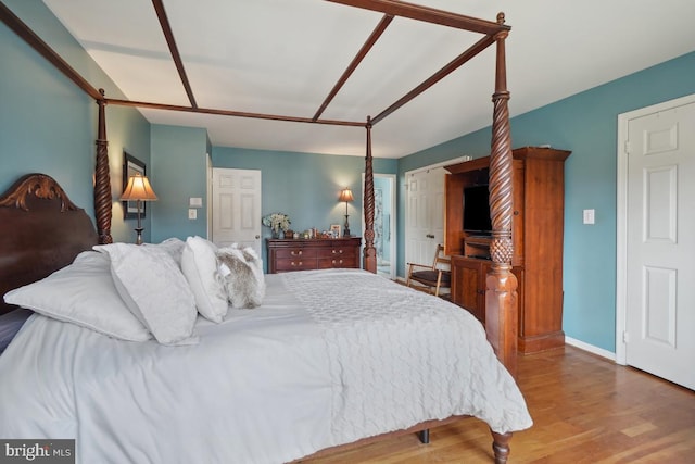 bedroom with baseboards and wood finished floors