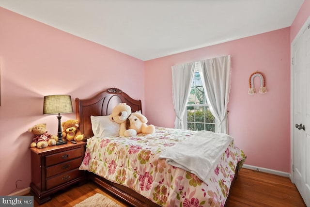 bedroom featuring baseboards and wood finished floors