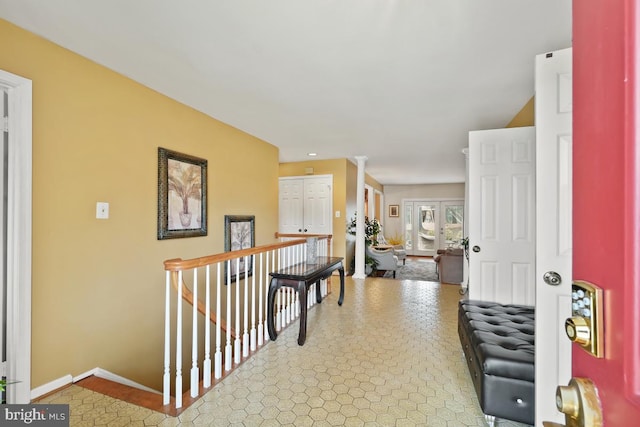 corridor featuring an upstairs landing and baseboards