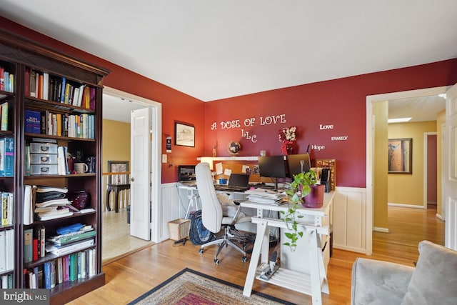 home office featuring a wainscoted wall and wood finished floors