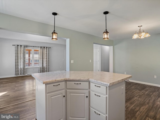 kitchen with baseboards, a center island, dark wood-style flooring, and light countertops