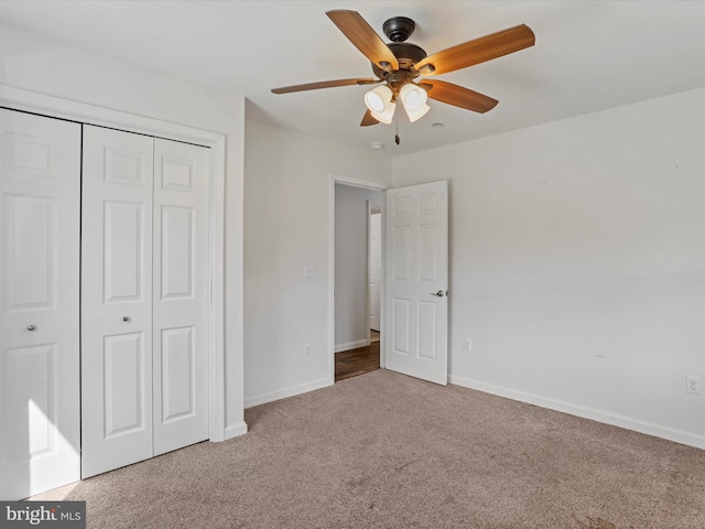 unfurnished bedroom featuring a closet, baseboards, ceiling fan, and carpet flooring