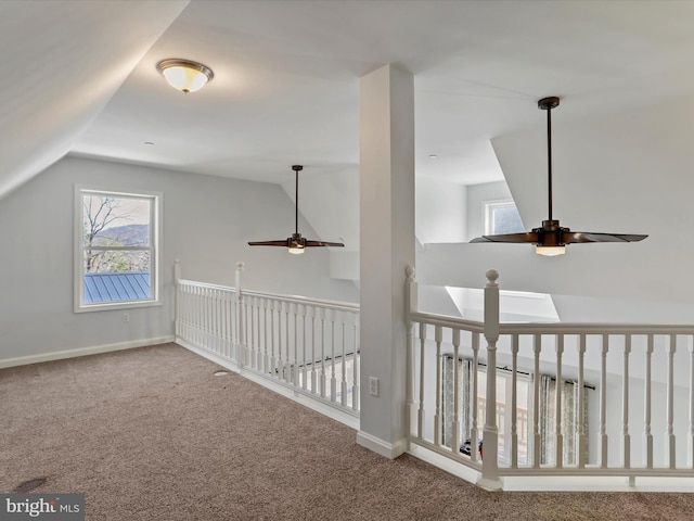 hall featuring lofted ceiling, baseboards, and carpet floors