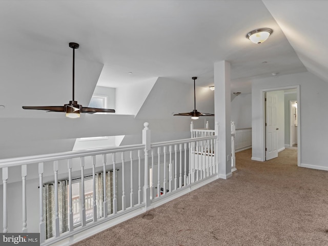 hallway with baseboards, carpet, an upstairs landing, and vaulted ceiling