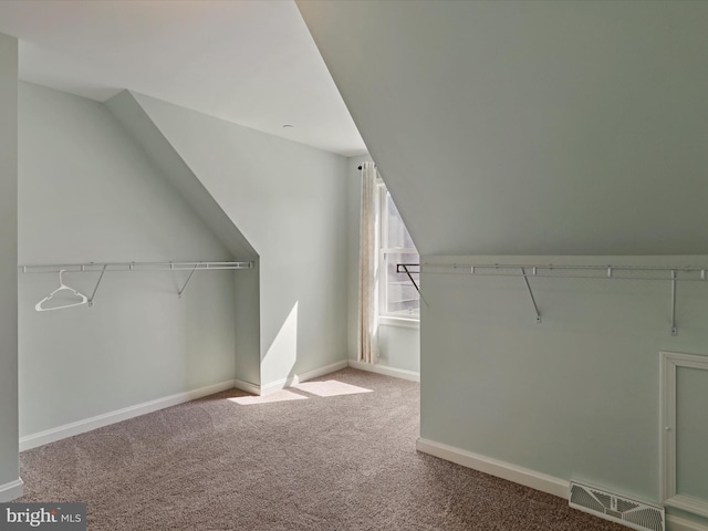 walk in closet with lofted ceiling, carpet, and visible vents