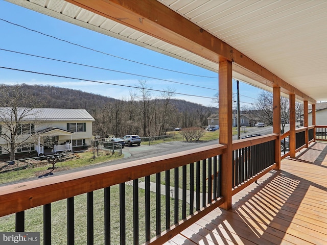 wooden deck with a porch and a view of trees