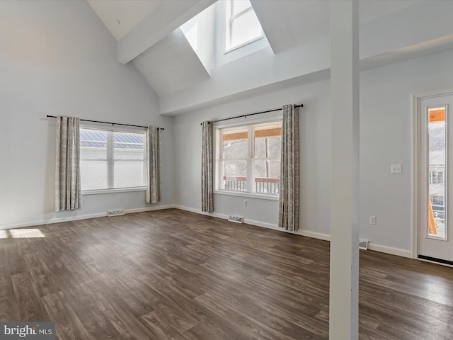 spare room with dark wood-style floors, a skylight, and baseboards