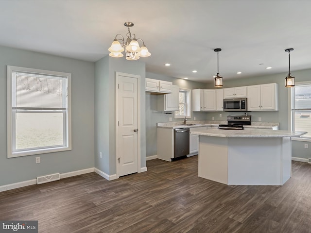 kitchen with dark wood-style floors, white cabinetry, stainless steel appliances, and baseboards