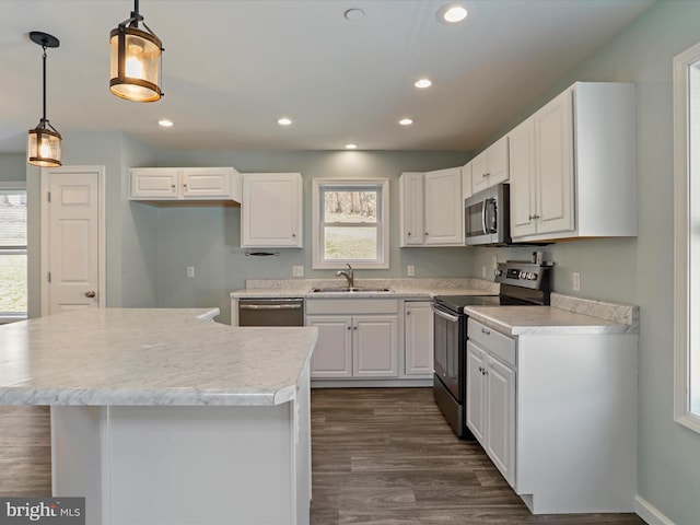 kitchen with dark wood finished floors, recessed lighting, appliances with stainless steel finishes, white cabinetry, and a sink