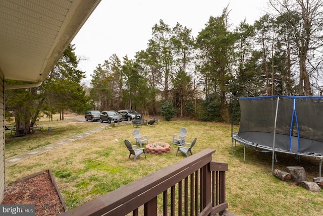 view of yard with a fire pit and a trampoline