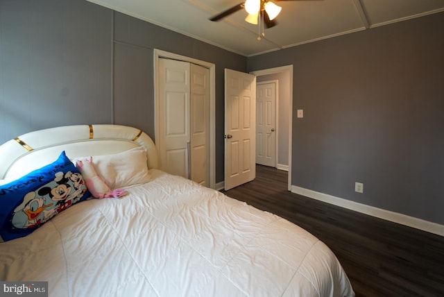 bedroom with ceiling fan, baseboards, ornamental molding, wood finished floors, and a closet